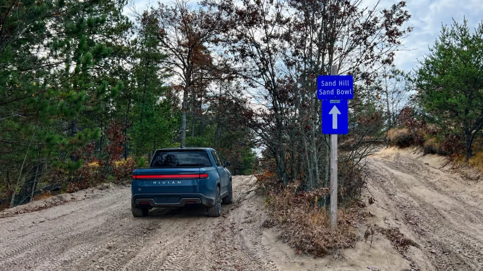 A Rivian R1T on the sandy Meridian Road in Michigan