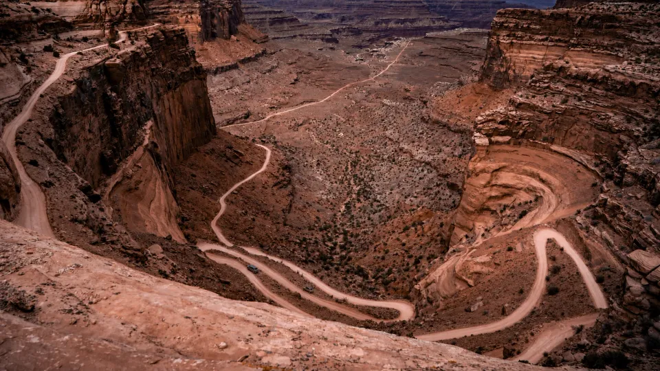 Two electric trucks on the lower part of Shafer Trail in Utah
