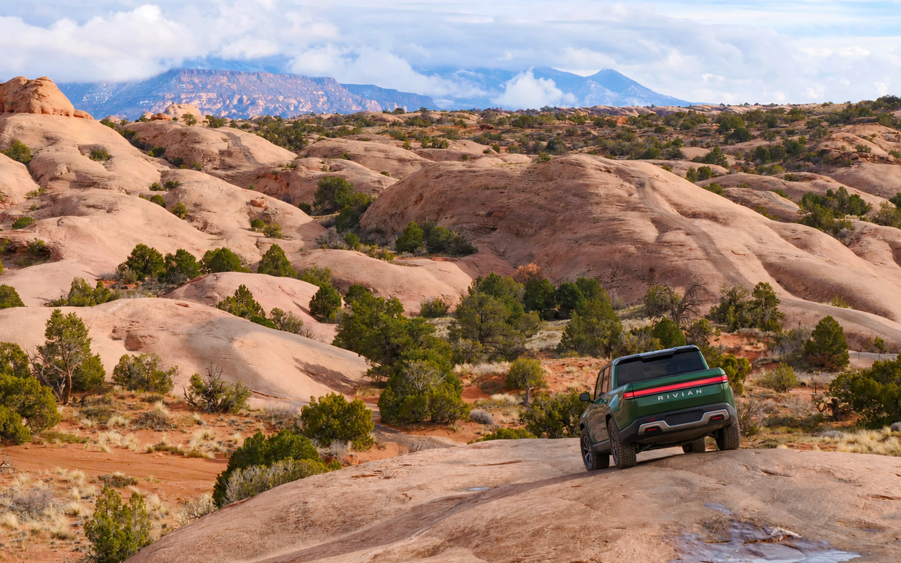 A Rivian R1T climbing a sandstone fin on Fins and Things