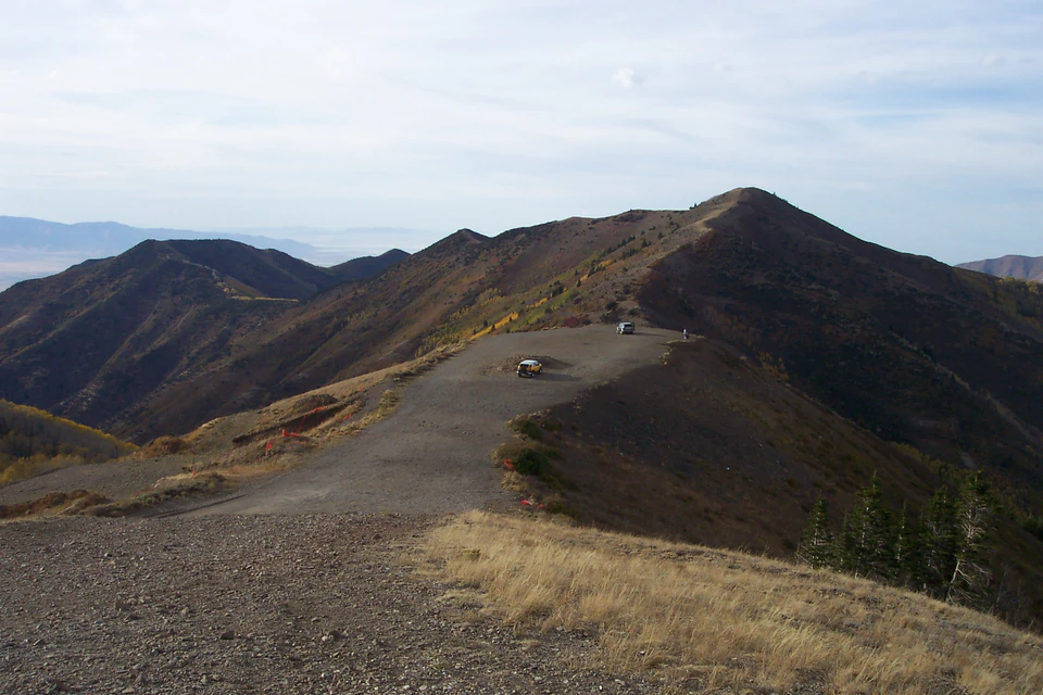 Gravel road and parked off-road vehicles on a high Oquirrh Mountain ridge at Copper Mine Overlook.