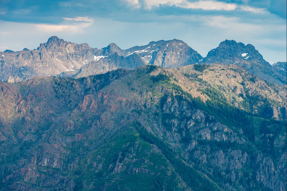 Jagged Seven Devils Mountains beyond the steep forested and basalt walls of Hells Canyon.