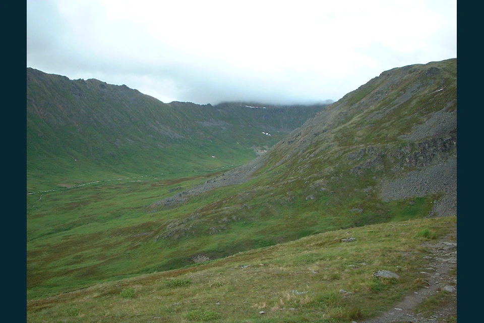 Broad alpine valley and rugged Talkeetna Mountain slopes viewed west from Hatcher Pass.
