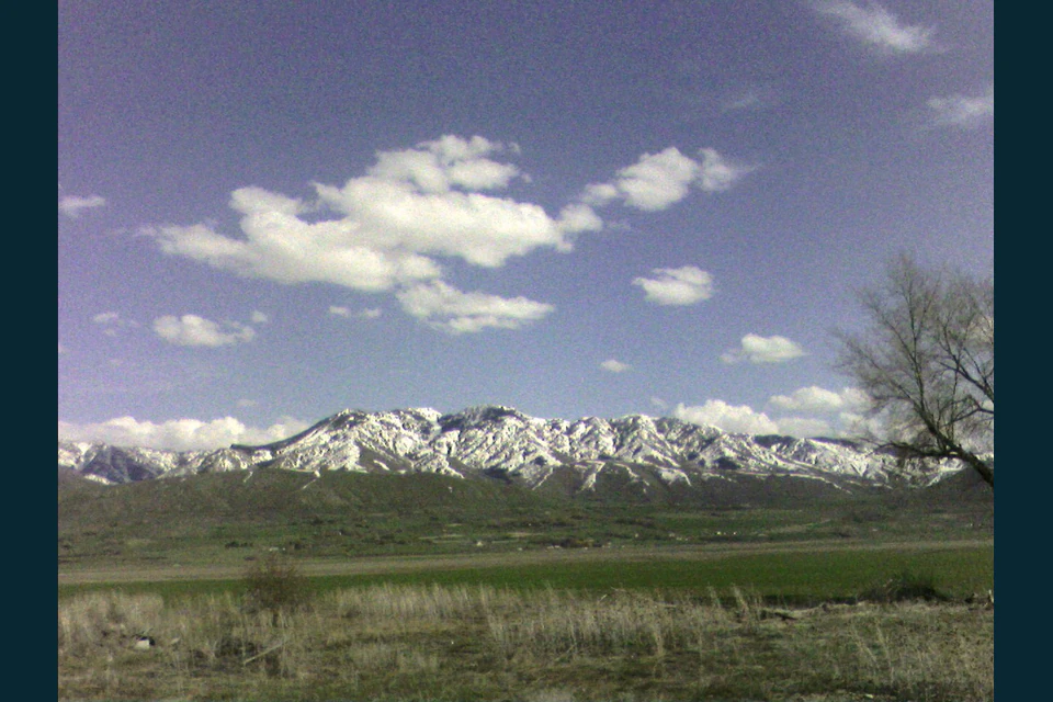 Wide view across green Cache Valley toward the Bear River Range.