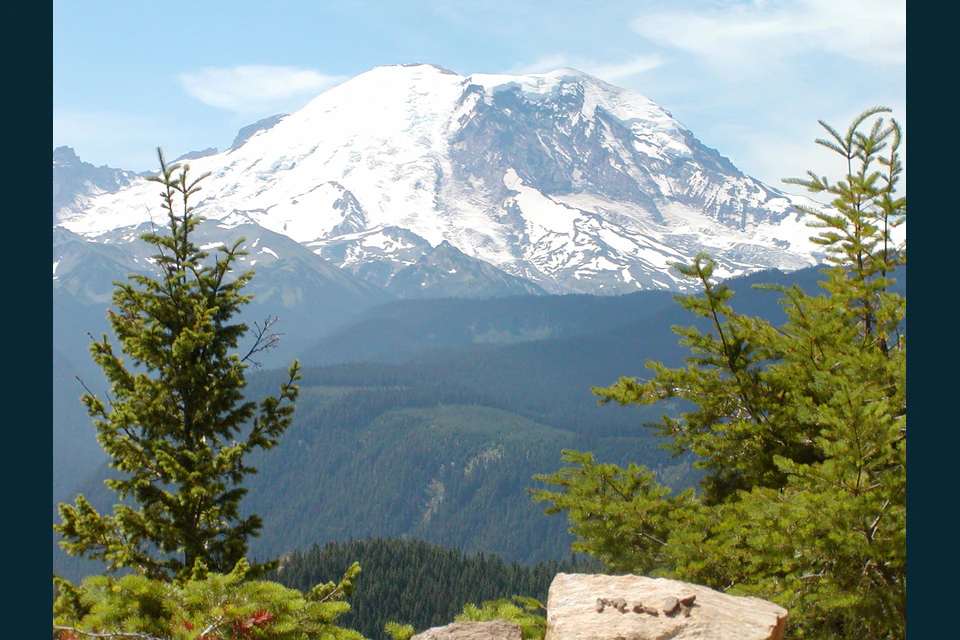 Mount Rainier above green Cascade foothills, seen from the trail near Sun Top Lookout.