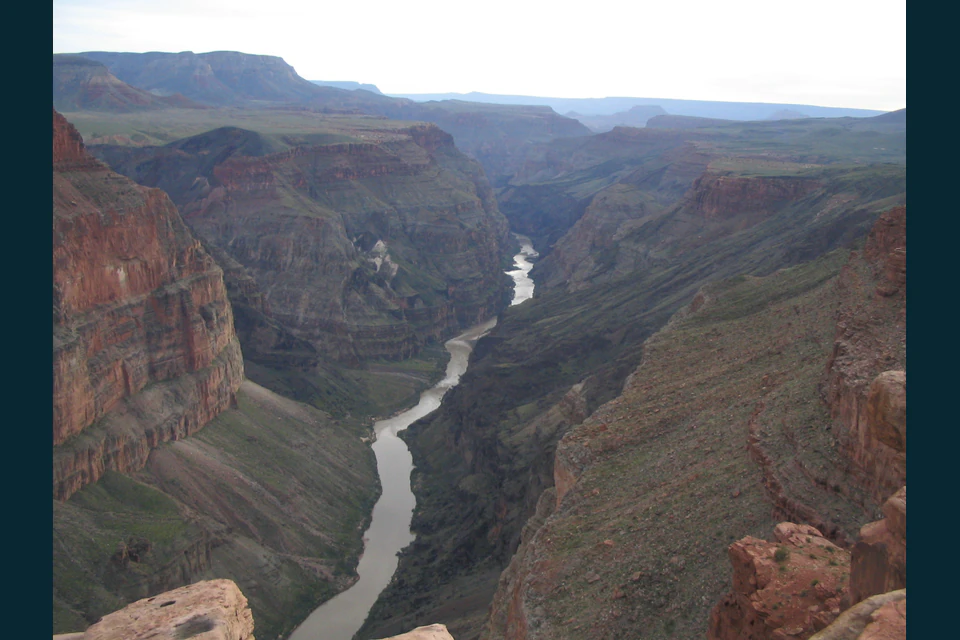 Colorado River winding through the deep layered red walls of the Grand Canyon below Toroweap Overlook.